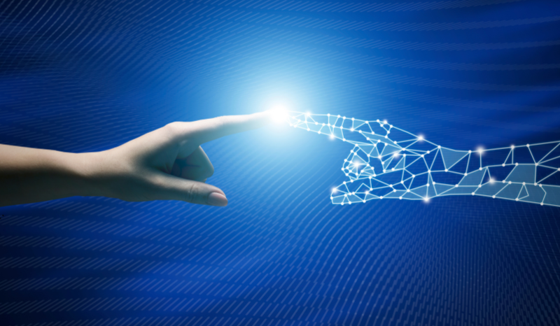 Image of a human hand touching a digital one